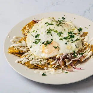 Chilaquiles - tortilla chips, tomatillo salsa, eggs, queso fresco, lime crema, onions and cilantro
 [vegetarian]