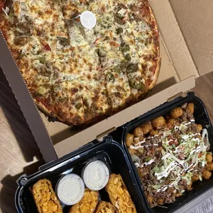 a pizza and chicken wings in a box