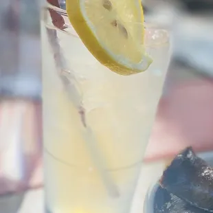 a glass of lemonade with a slice of lemon