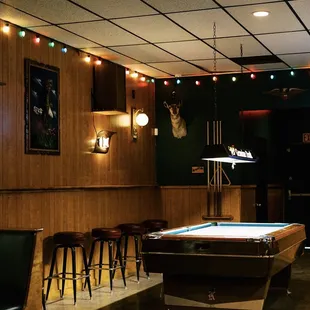 a pool table and bar stools