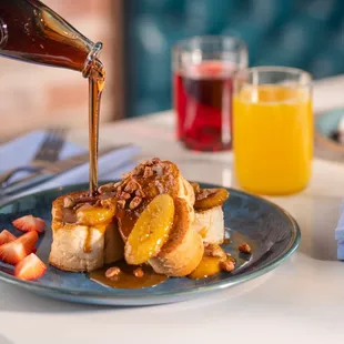 a person pouring syrup over a plate of food