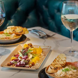 two plates of food and a glass of wine