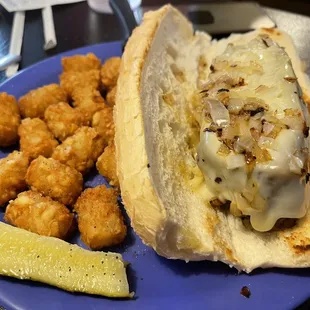 Meatloaf sandwich with cheese and tots.