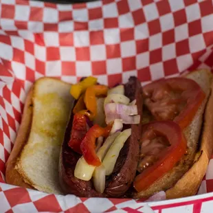 a hot dog with tomatoes, onions, and onions