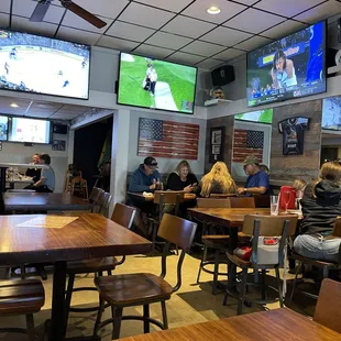 people sitting at tables watching tvs