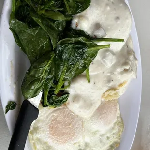 a plate of food with spinach and eggs