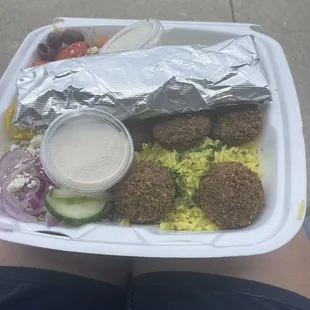 Falafel bowl. Rice, falafel, lettuce, tomatoes, olives, banana peppers, pickles, onion, pita bread and tzatziki sauce.
