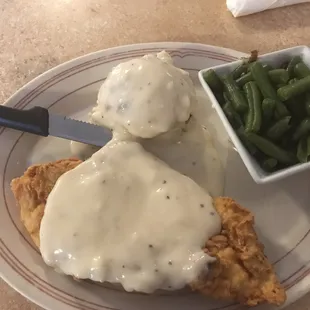 Chicken fried chicken with green beans and mashed potatoes.