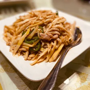 a plate of noodles with meat and vegetables