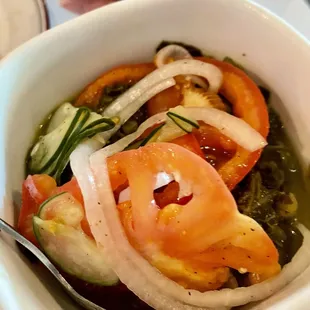 Greens with tomatoes, cucumber and onions on top.