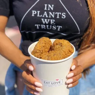 a woman holding a cup of food