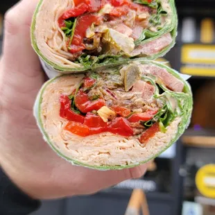 a hand holding a sandwich