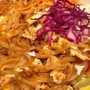 Pad Thai with chicken. Stir fried rice noodles mixed in with scrambled eggs, cabbage, chopped peanuts, carrot slivers.