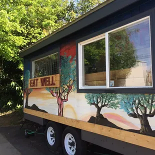 a food truck with painted trees on the side