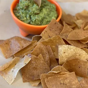 a plate of chips and a bowl of guacamole