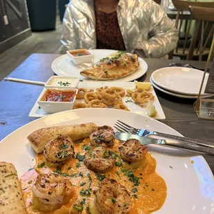 a woman sitting at a table with plates of food