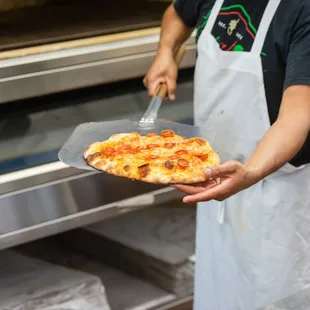 a person holding a pizza