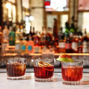 three cocktails on a bar