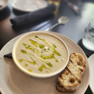 a bowl of soup and a piece of bread