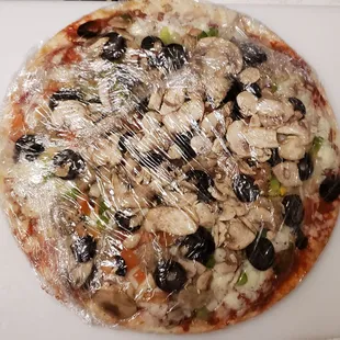a pizza covered in plastic wrap