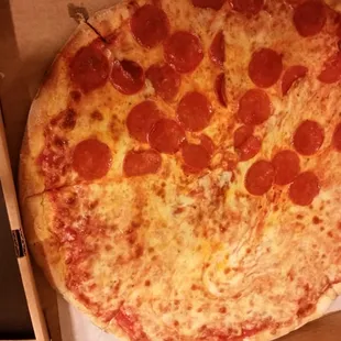 Thin and round , half cheese and half pepperoni.