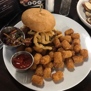 Pulled pork sandwich with pineapple slaw on the side and tater tots.