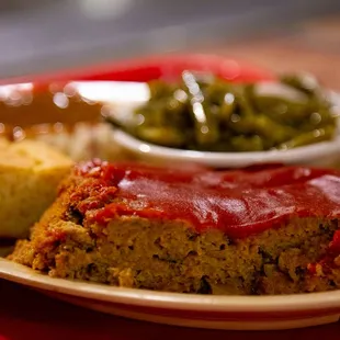 a plate of meatloaf with a side of green beans