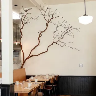 a dining room with a tree on the wall