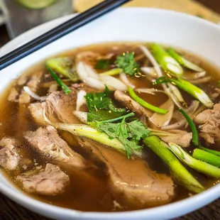 a bowl of soup and chopsticks