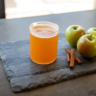 a glass of apple cid and cinnamon sticks