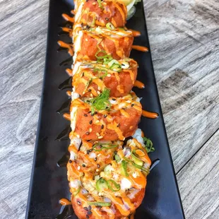 USC Trojan Roll - IN: tempura shrimp, cream cheese, avocado, imitation crab, cucumber. OUT: Spicy Tuna, Eel Sauce, Spicy Sauce, Sesame Seeds