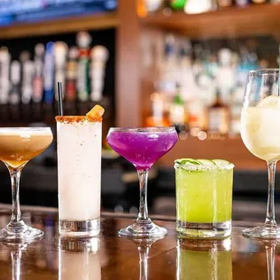 a variety of cocktails on a bar