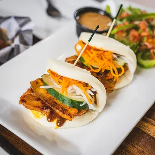 Spicy Pork Buns (2). Grilled spicy pork belly on sweet flour buns served with salad.