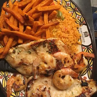 Chicken breast topped with shrimp. Sides are Mexican rice and sweet potato fries.