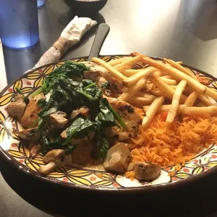 Chicken breast topped with spinach and mushrooms. Sides are Mexican rice and fries.