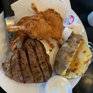 a plate of steak, potatoes, and a potato