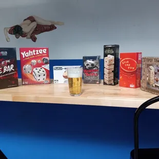 a shelf with books and a glass of beer