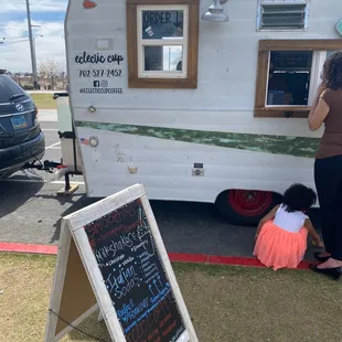 a woman and her dog in front of a trailer