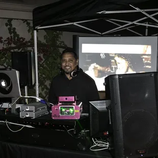 DJ with two large flat screens playing music videos synced to songs he played