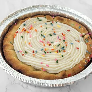 a pie with frosting and sprinkles