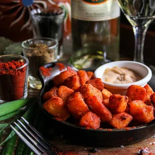 a bowl of fried potatoes and a glass of wine