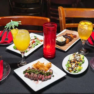 a table set with plates of food and drinks