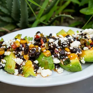 a plate of black beans, avocado, and feta cheese