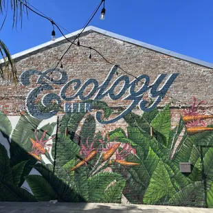 a brick building with a mural of birds of paradise