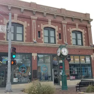 a brick building with a clock on the corner