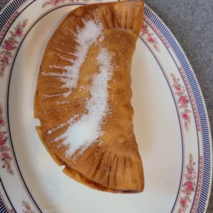 a pastry on a plate with sugar on top