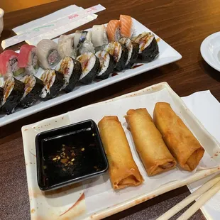 Furthest to the front -  a rainbow roll A Godzilla roll  Spring rolls