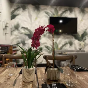 a table setting with a flower in a vase