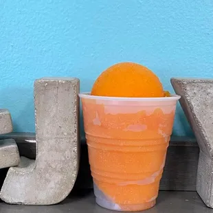 an orange in a plastic cup