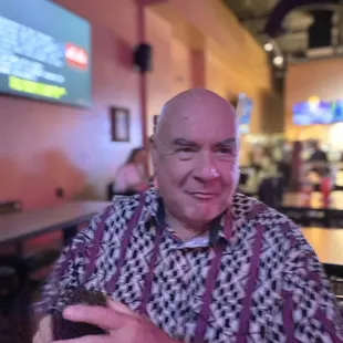 a man sitting at a table with a cell phone in his hand